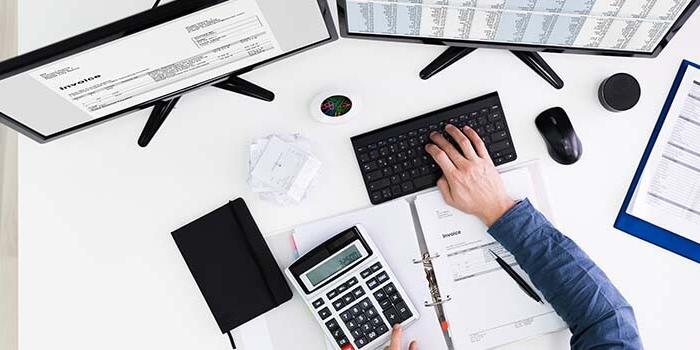 An IT office working table from above, person also using keyboard An IT office working table from above, person also using keyboard