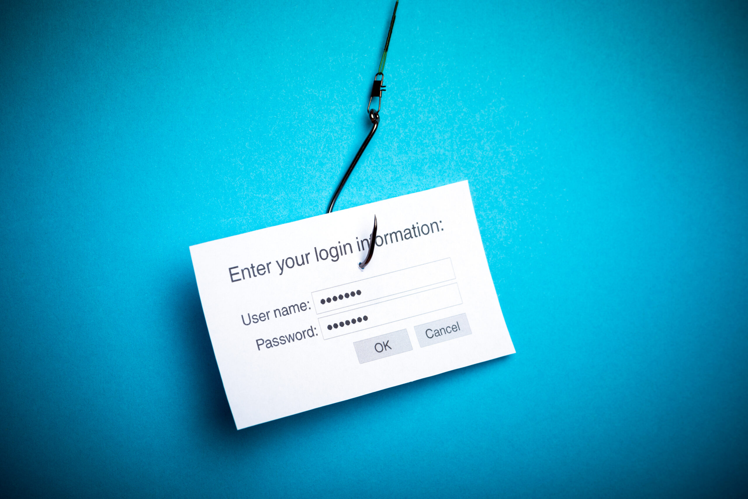 A conceptual image of a fishing hook with an email symbol, illustrating the deceptive nature of phishing emails aiming to acquire sensitive data, accompanied by article text offering preventative tips.”