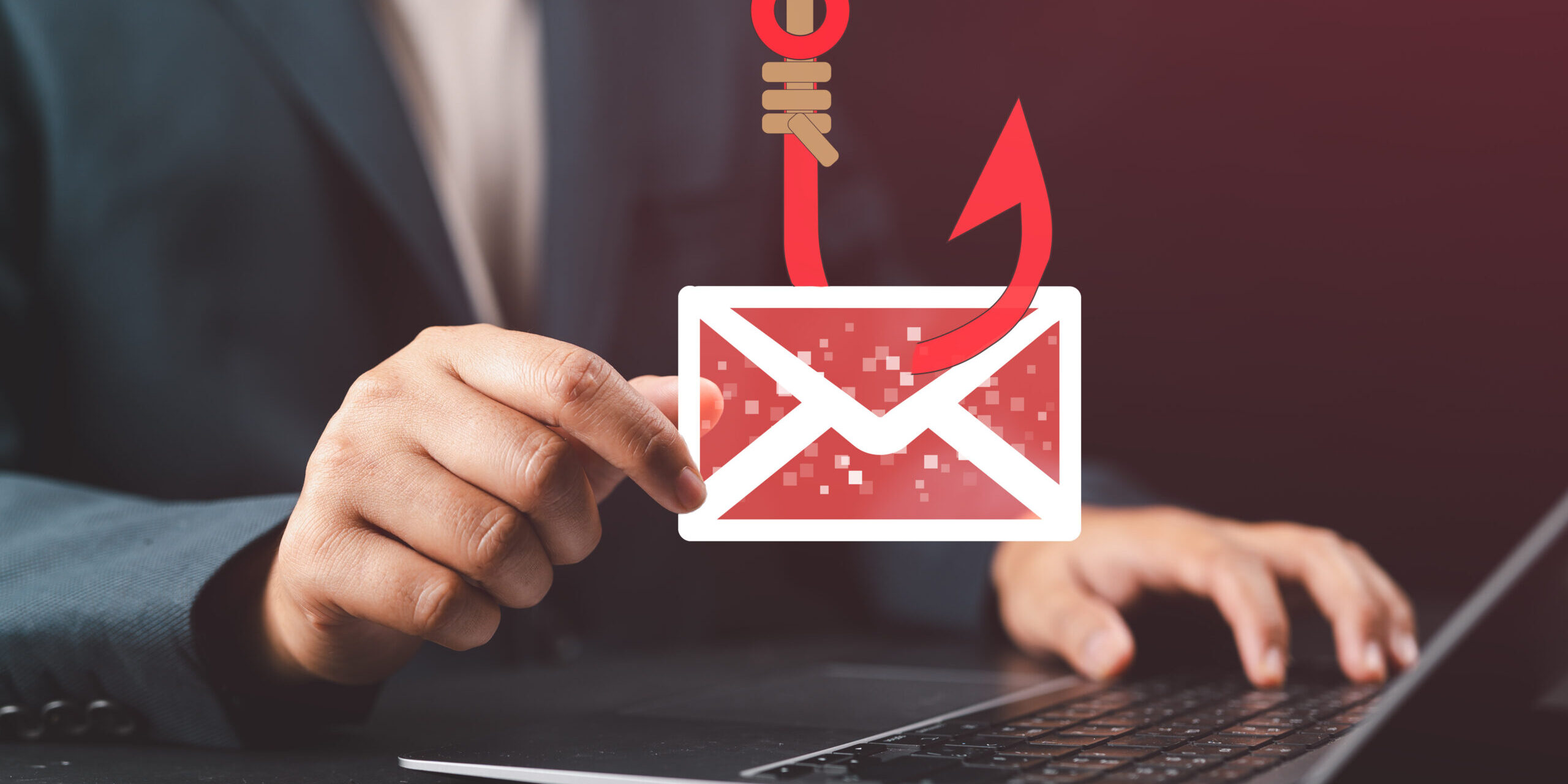 How to Stop Someone From Spoofing Your Domain Business professional holding a phishing email icon over a laptop, illustrating email spoofing attacks and domain protection through email authentication protocols.